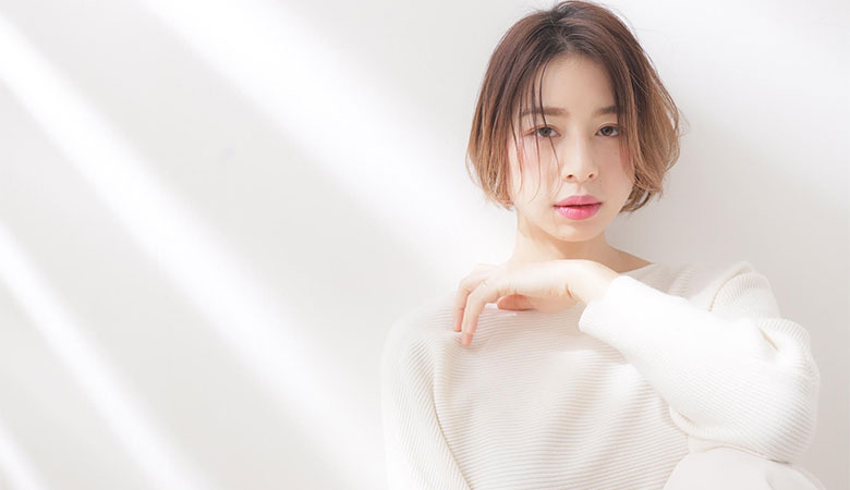 自然光の中で微笑むショートボブの女性モデル